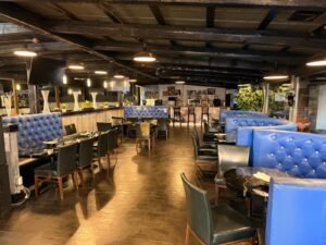 Nations Rhythm dining room with royal blue booths, black seating and the bar in the background
